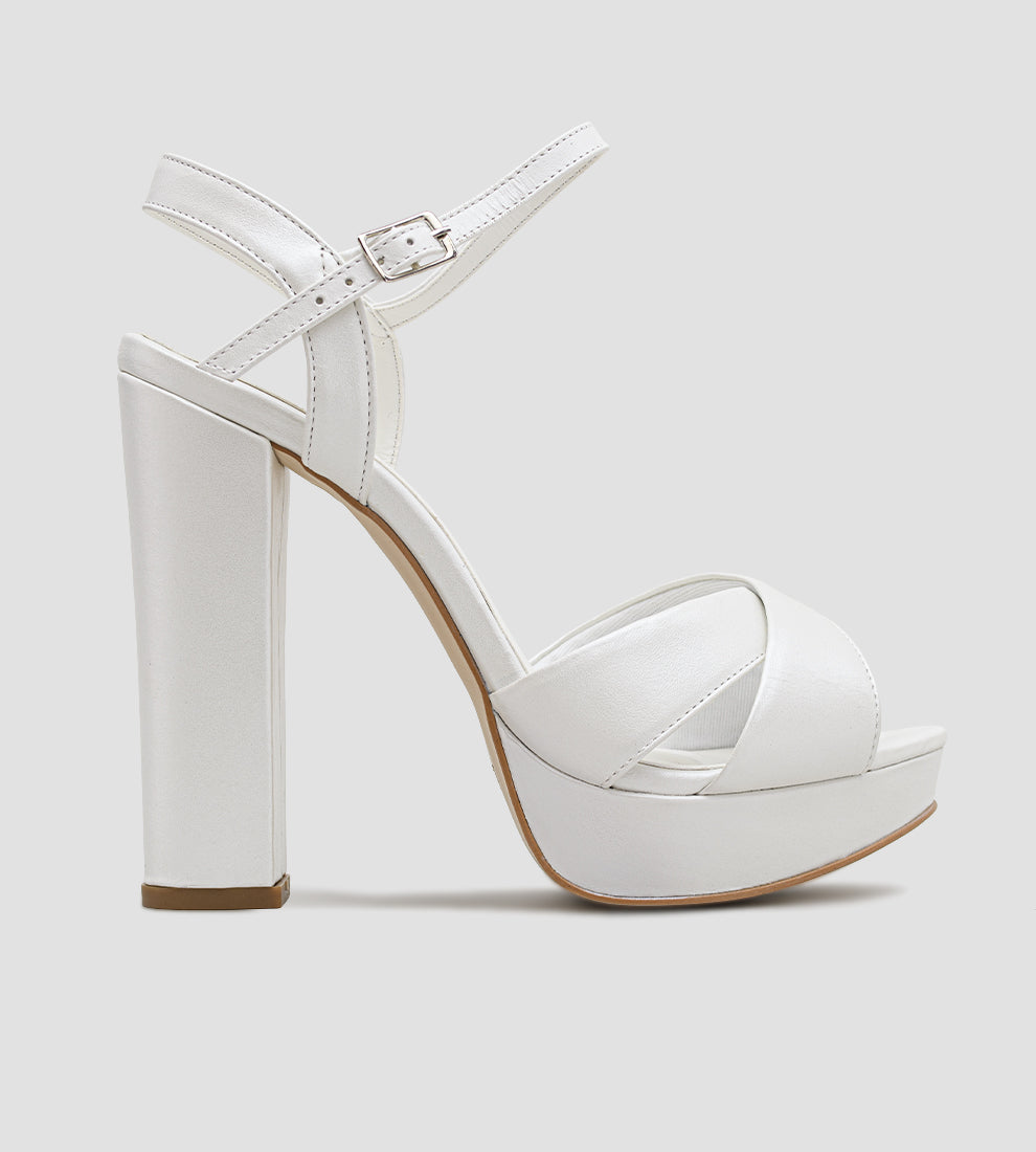 Sandália de noiva em couro branco perolado com salto alto de 12 cm, meia-pata frontal e tira com fivela no tornozelo.