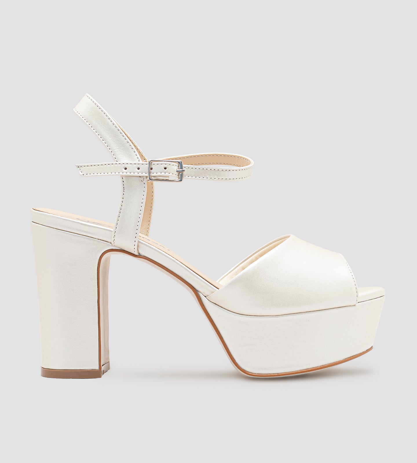 Sandália de noiva em couro perolado off white com plataforma e salto de 10 cm, tira frontal larga e fechamento ajustável no tornozelo.