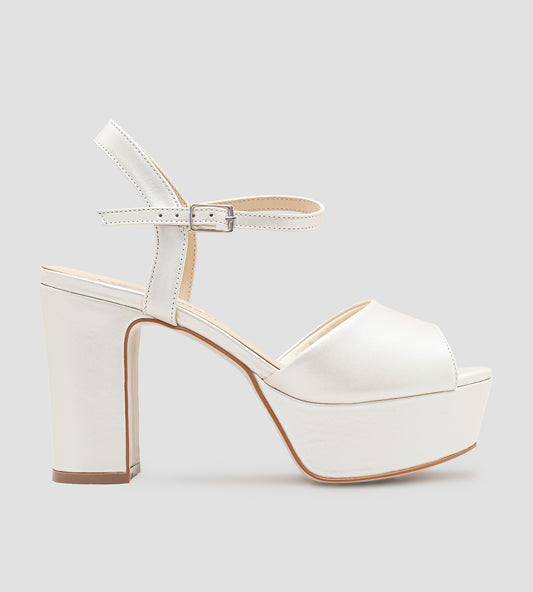 Sandália de noiva em couro perolado off white com plataforma e salto de 10 cm, tira frontal larga e fechamento ajustável no tornozelo.