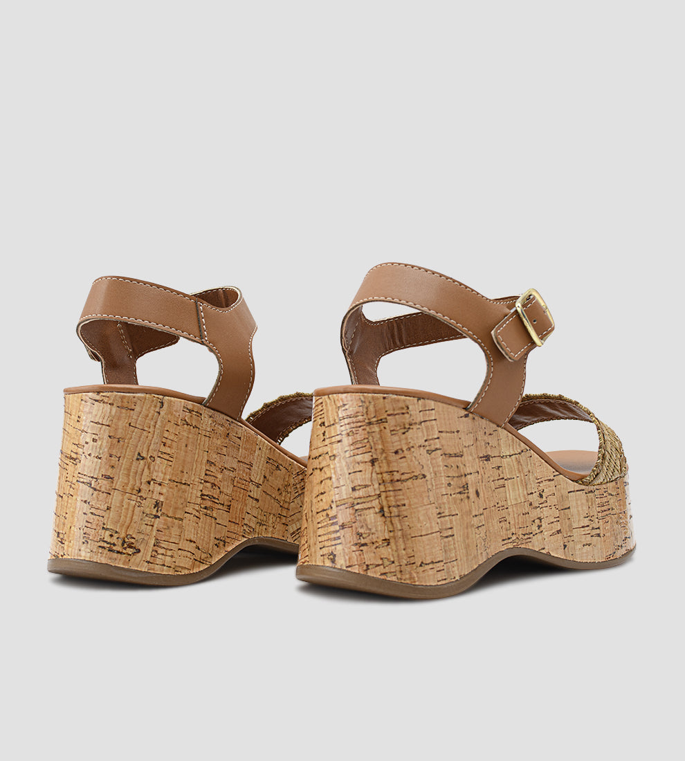 Sandália anabela feminina com salto plataforma em cortiça, tiras em malha inglesa e fecho de fivela dourada no tornozelo.