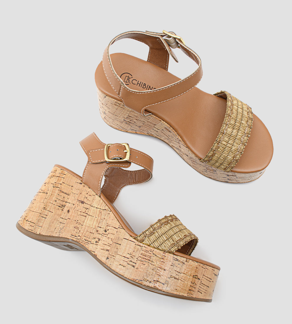 Sandália anabela feminina com salto plataforma em cortiça, tiras em malha inglesa e fecho de fivela dourada no tornozelo.