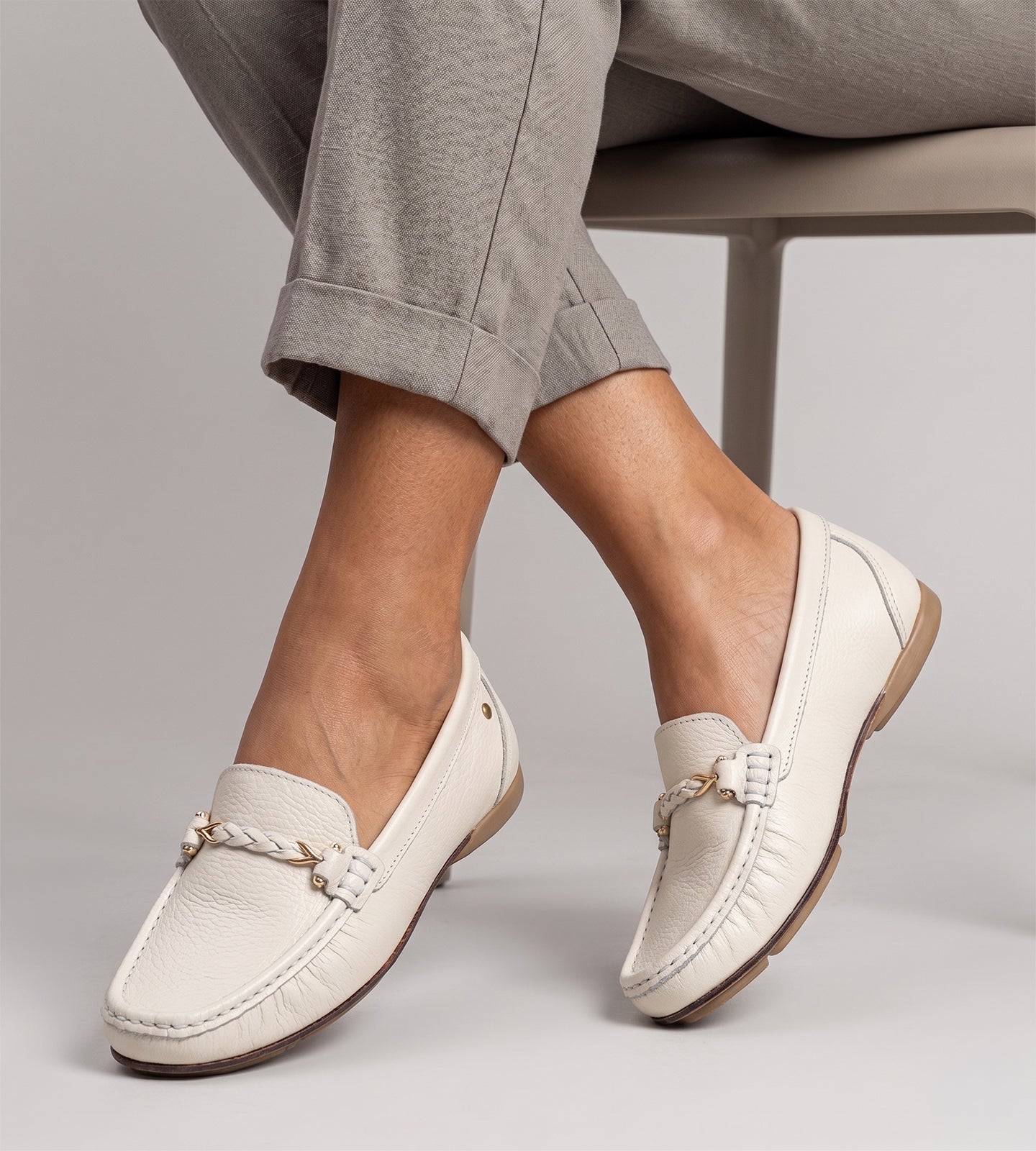 mocassim feminino bege em couro legítimo com detalhe trançado frontal e solado baixo confortável.