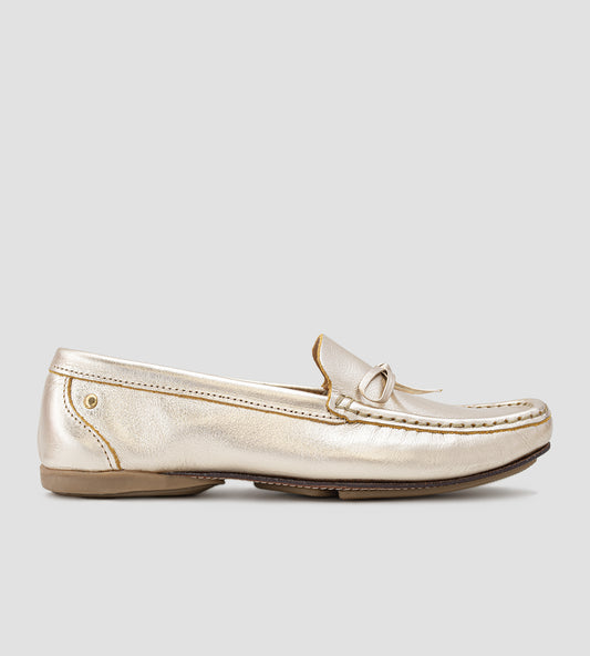 Mocassim feminino em couro legítimo dourado com laço frontal, acabamento sofisticado e design slip-on, ideal para looks elegantes e confortáveis no dia a dia.