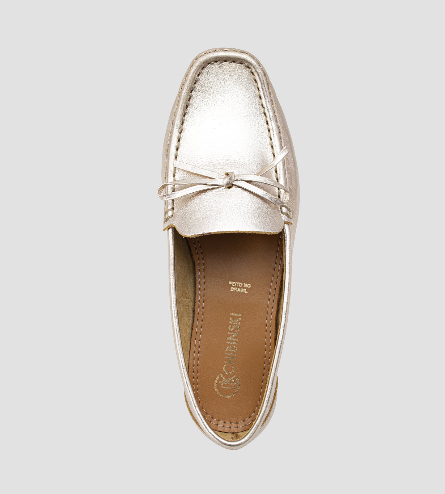 Mocassim feminino em couro legítimo dourado com laço frontal, acabamento sofisticado e design slip-on, ideal para looks elegantes e confortáveis no dia a dia.