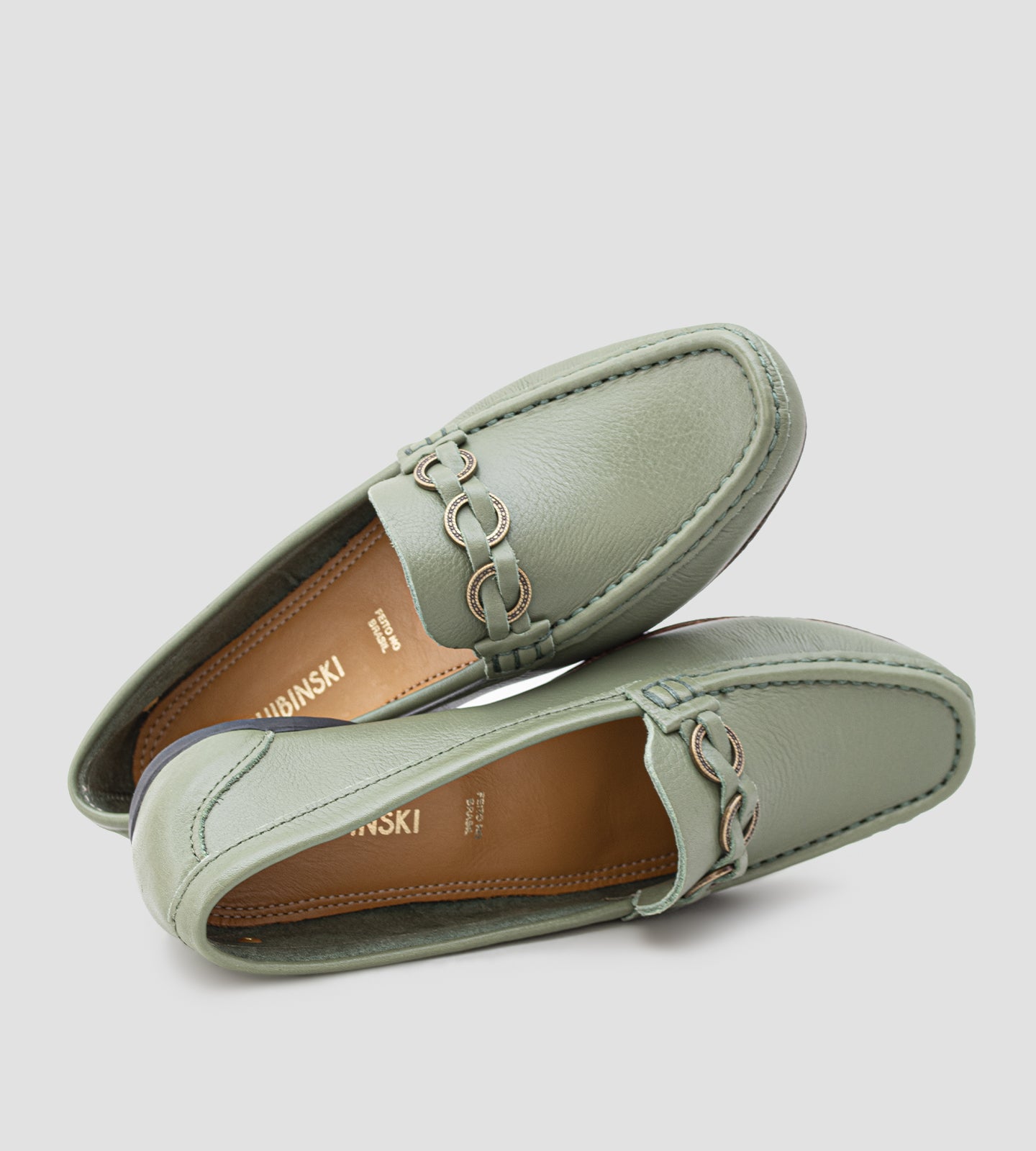 Mocassim feminino em couro verde com detalhe metálico frontal, design clássico e acabamento sofisticado.