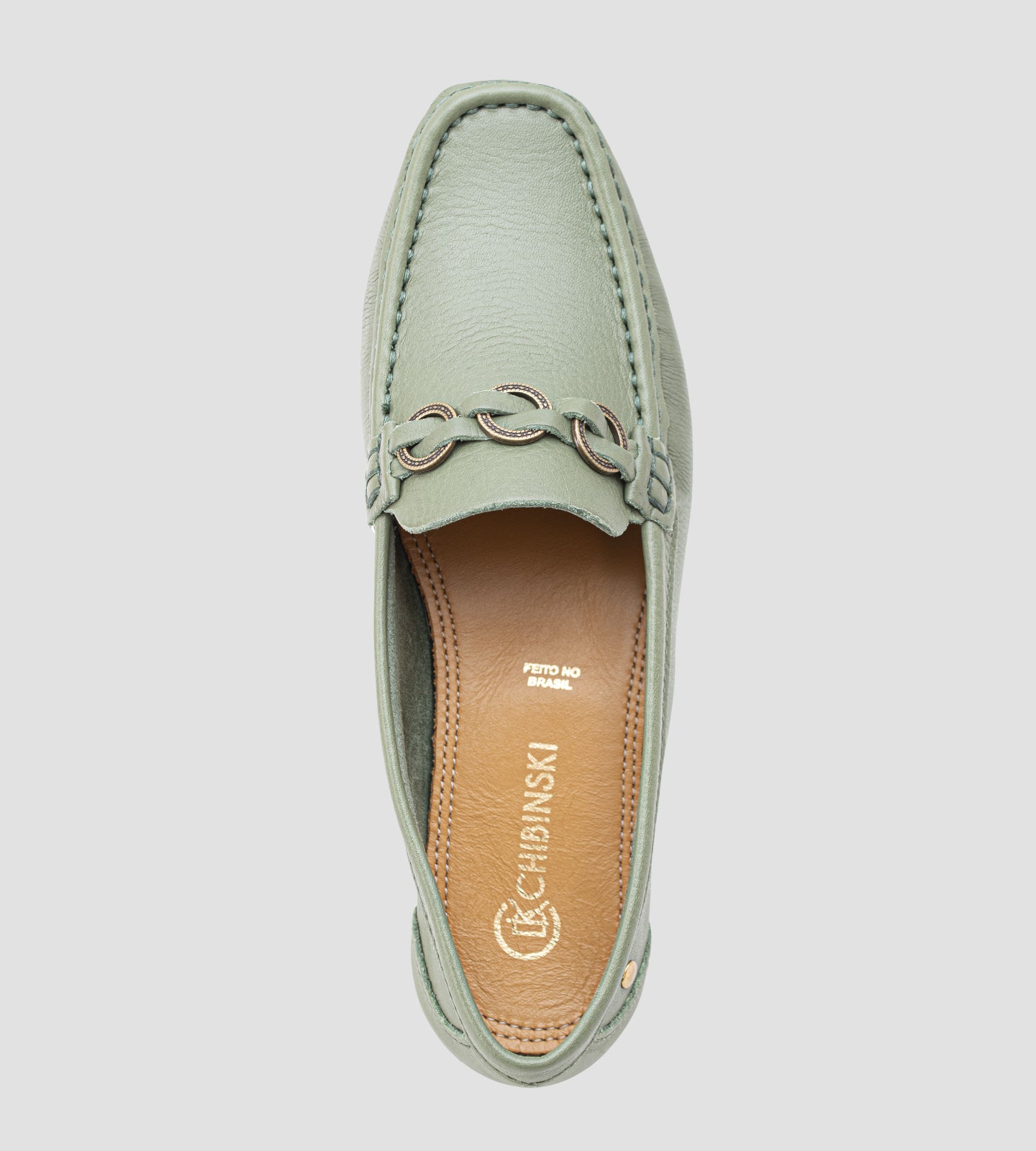 Mocassim feminino em couro verde com detalhe metálico frontal, design clássico e acabamento sofisticado.