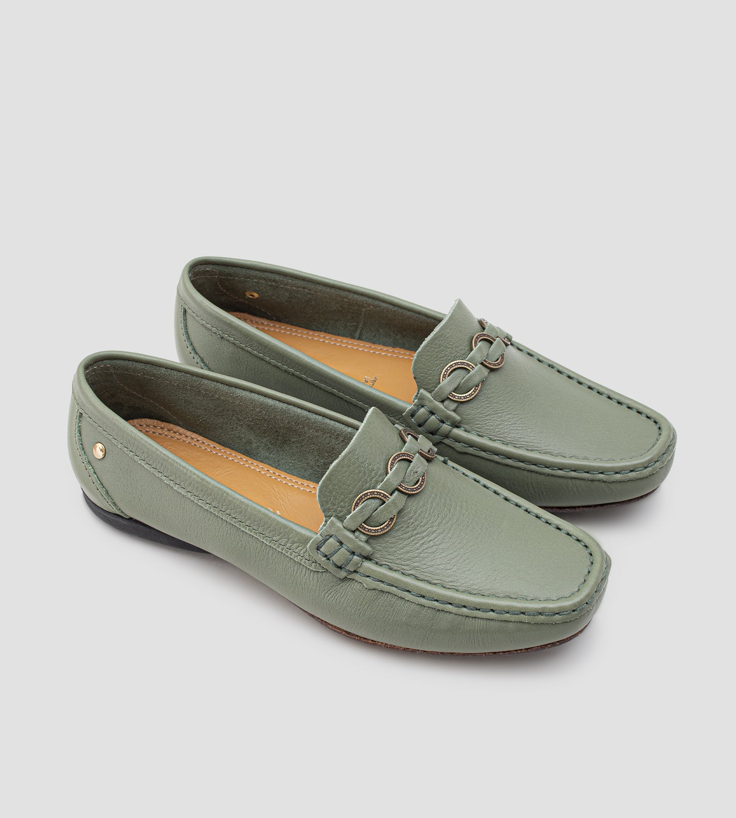Mocassim feminino em couro verde com detalhe metálico frontal, design clássico e acabamento sofisticado.