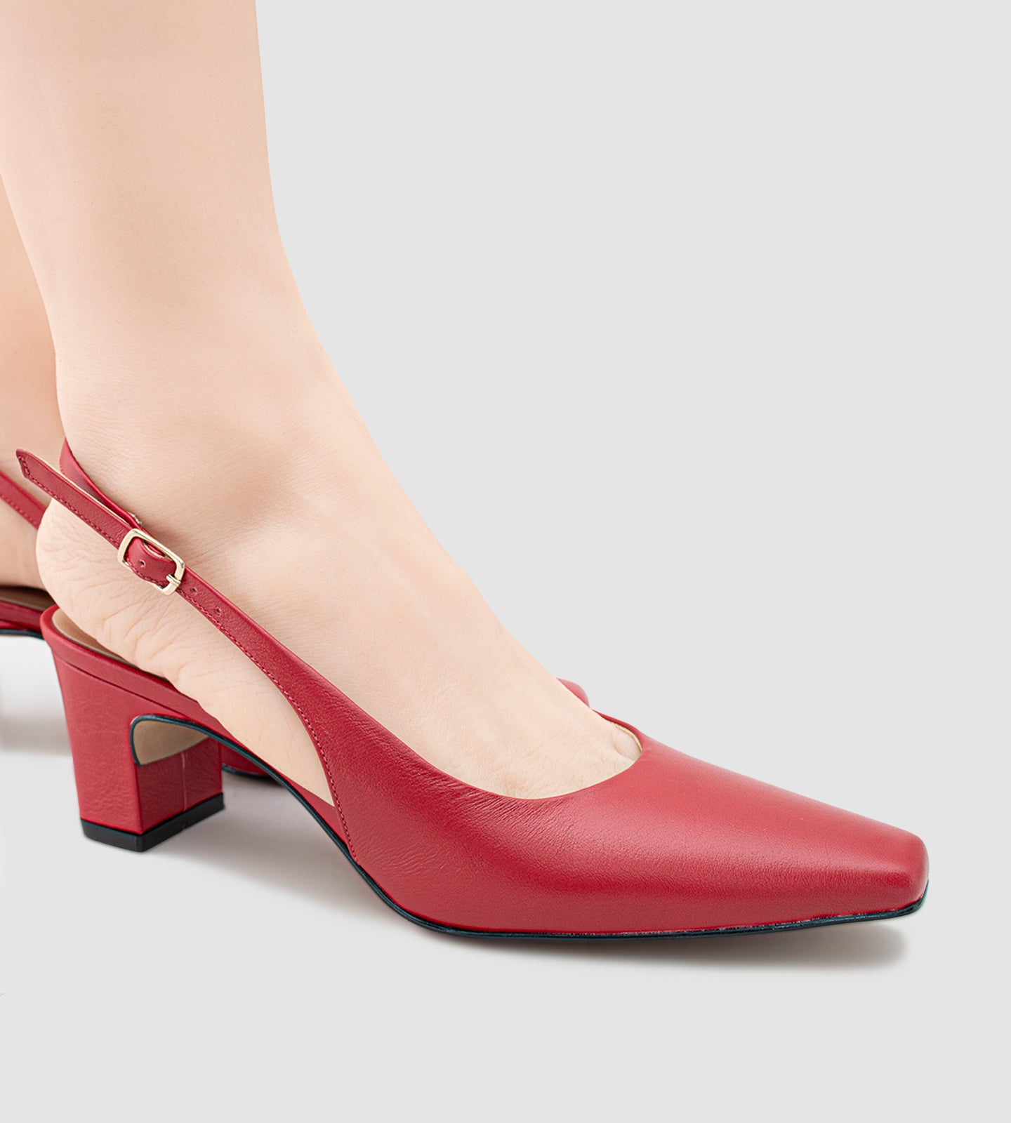 Scarpin slingback em couro vermelho, com salto grosso de 6cm e bico quadrado. Um modelo clássico e sofisticado, perfeito para quem busca conforto sem abrir mão da elegância. Ideal para diversas ocasiões, ele combina a praticidade do salto grosso com o estilo moderno do bico quadrado, garantindo um look refinado e confortável.