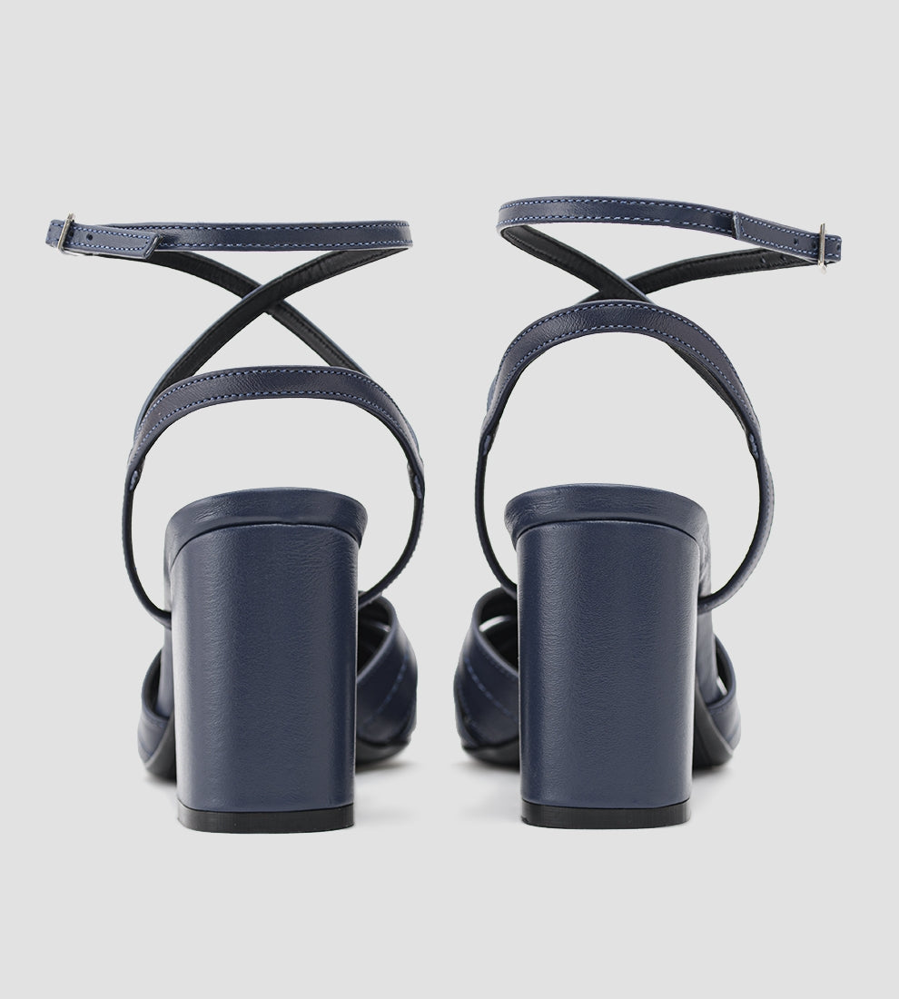 Sandália feminina azul marinho com tiras cruzadas, bico fino e salto bloco médio, elegante e confortável para looks casuais ou sociais.