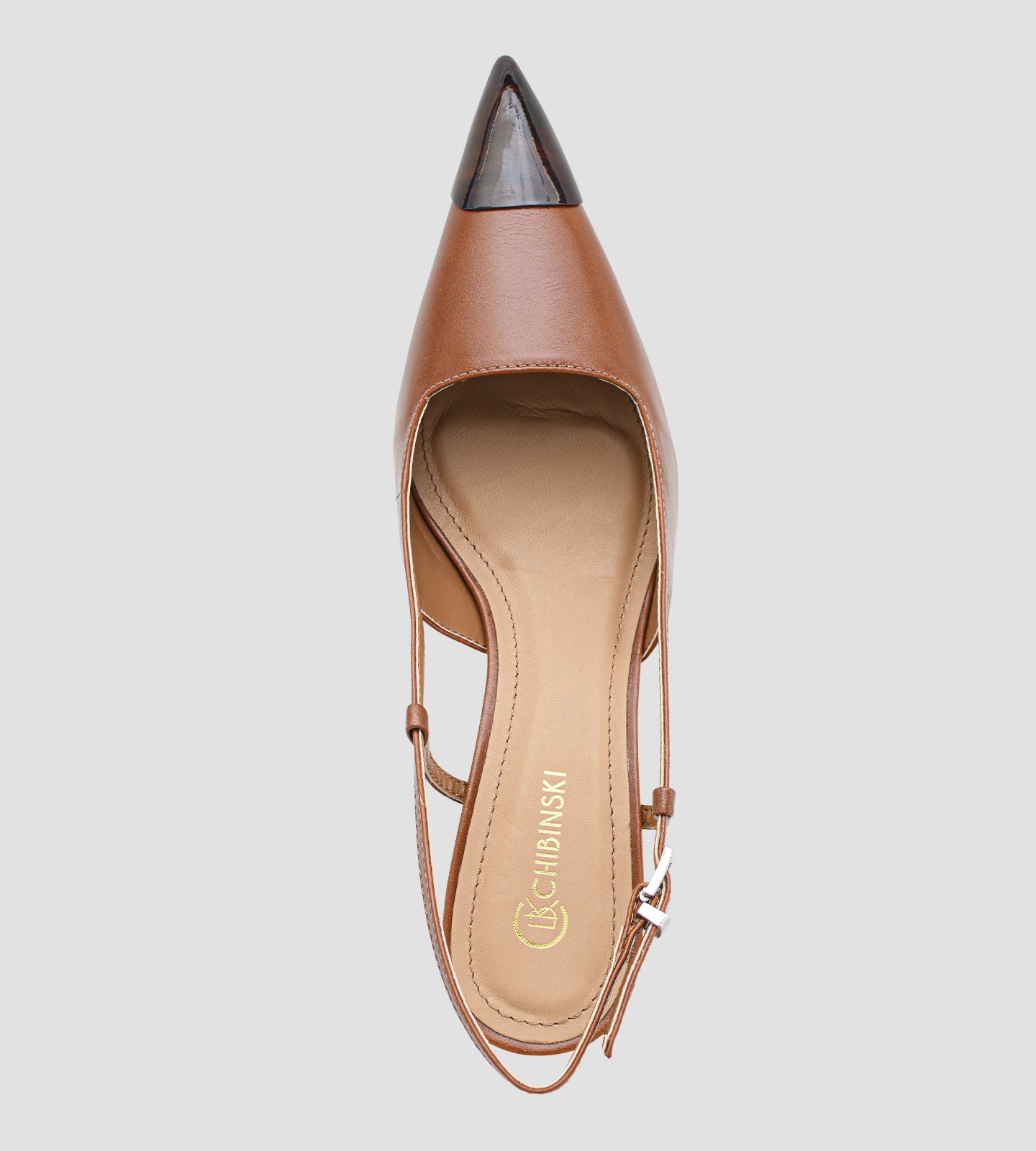 Fotografia de um par de sapatos femininos modelo scarpin slingback na cor caramelo sobre um fundo claro. O calçado possui bico fino com a ponta envernizada em estampa de tartaruga, além de um salto escultural de 6 centímetros com o mesmo padrão de tartaruga. O fechamento é feito por uma tira fina com fivela prateada ajustável no calcanhar.