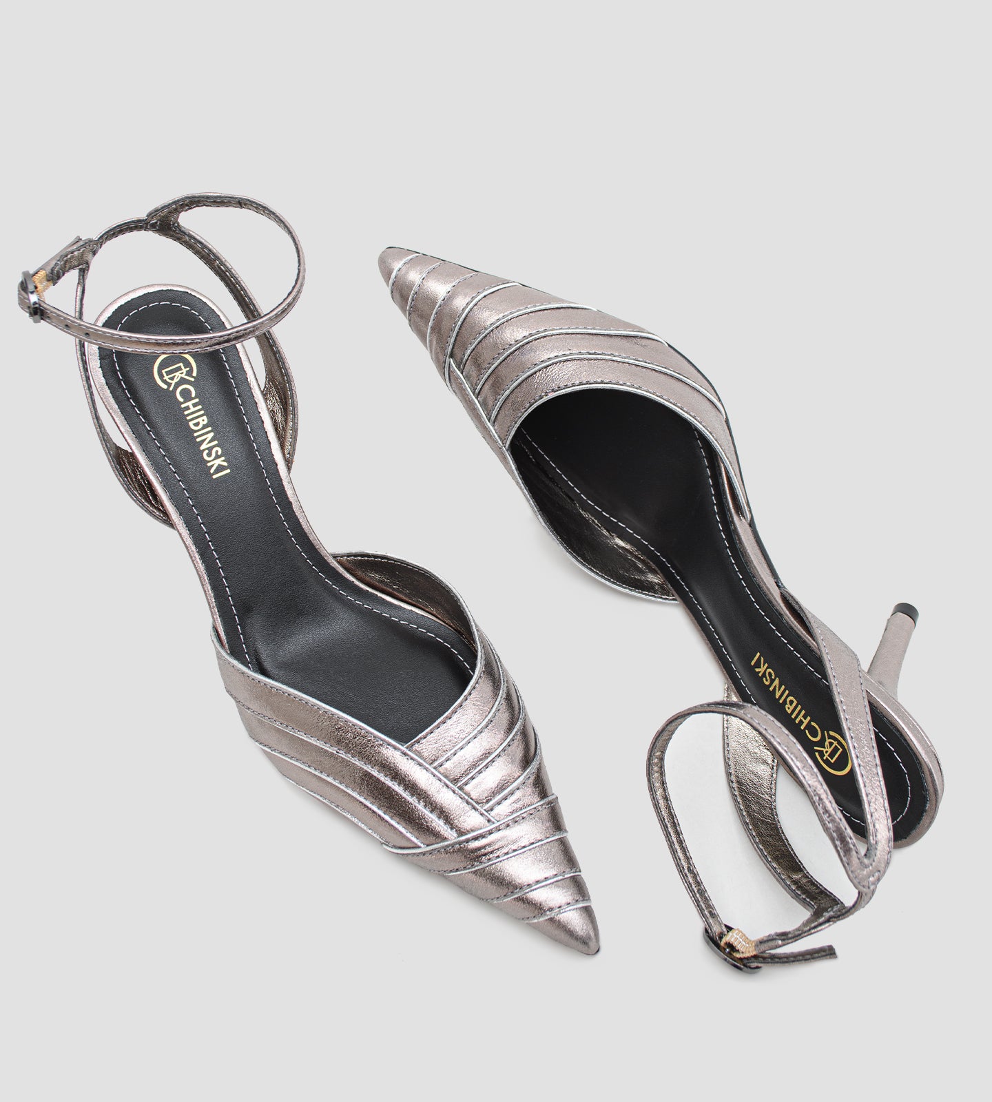 Scarpin slingback em couro metalizado com salto alto fino de 9cm, bico fino alongado, recortes frontais estruturados e tira no tornozelo com fivela ajustável, ideal para festa, casamento, formatura e eventos formais.