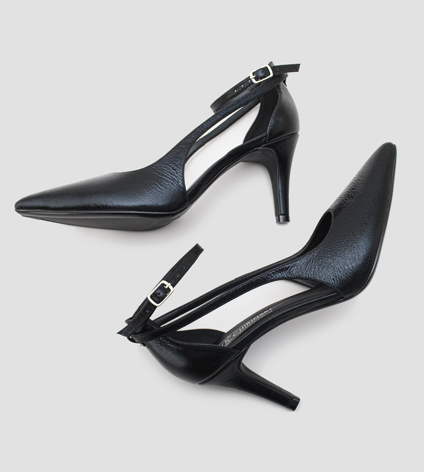 Scarpin feminino preto em couro com bico fino, recortes laterais e salto de 8cm.