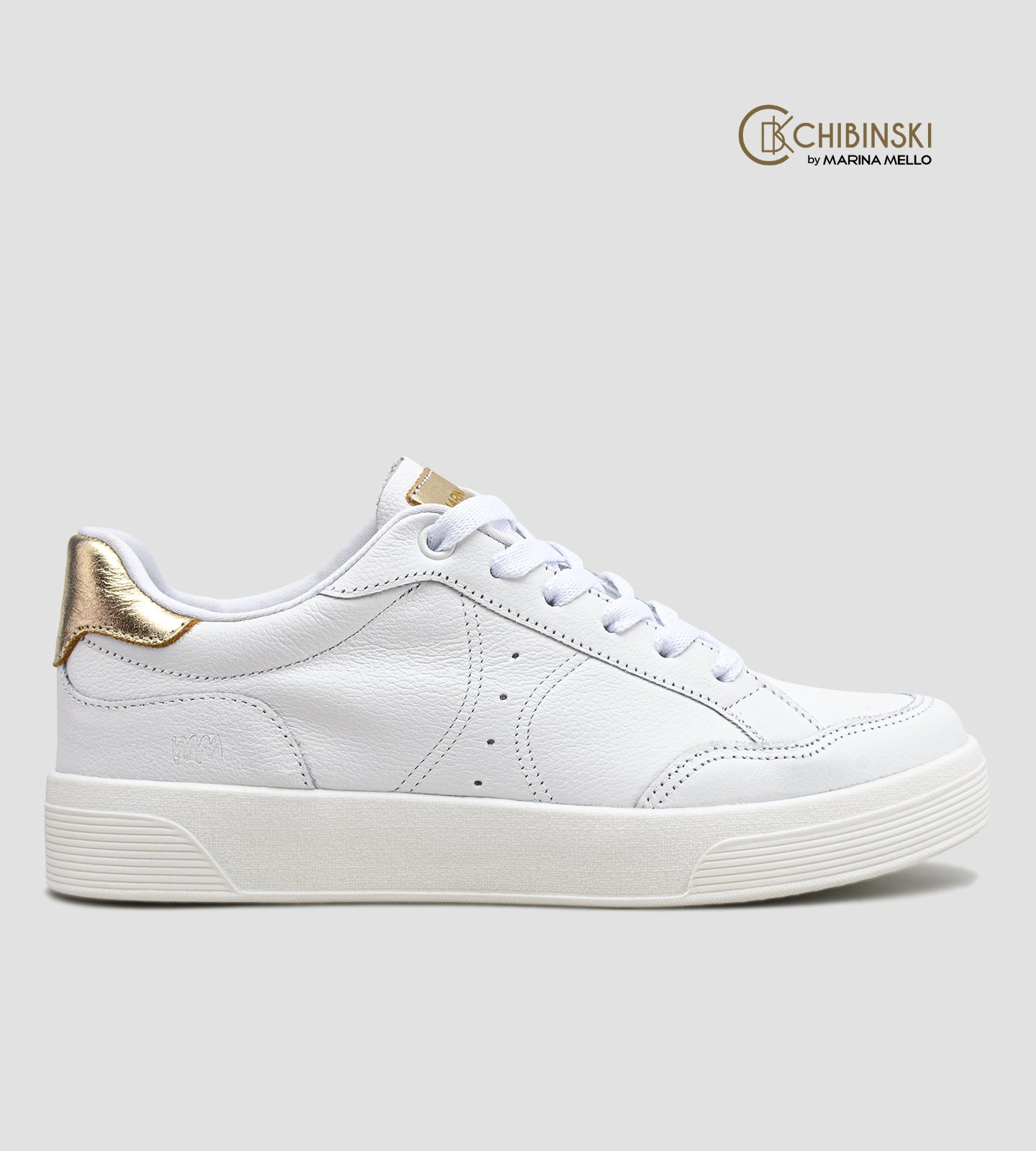 Tênis feminino em couro branco com detalhe dourado no calcanhar, cadarço branco e solado baixo, modelo casual da collab com Marina Mello.