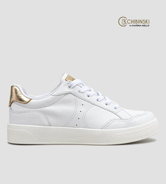 Tênis feminino em couro branco com detalhe dourado no calcanhar, cadarço branco e solado baixo, modelo casual da collab com Marina Mello.
