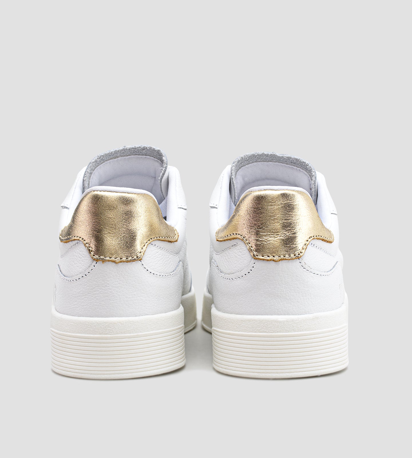 Tênis feminino em couro branco com detalhe dourado no calcanhar, cadarço branco e solado baixo, modelo casual da collab com Marina Mello.