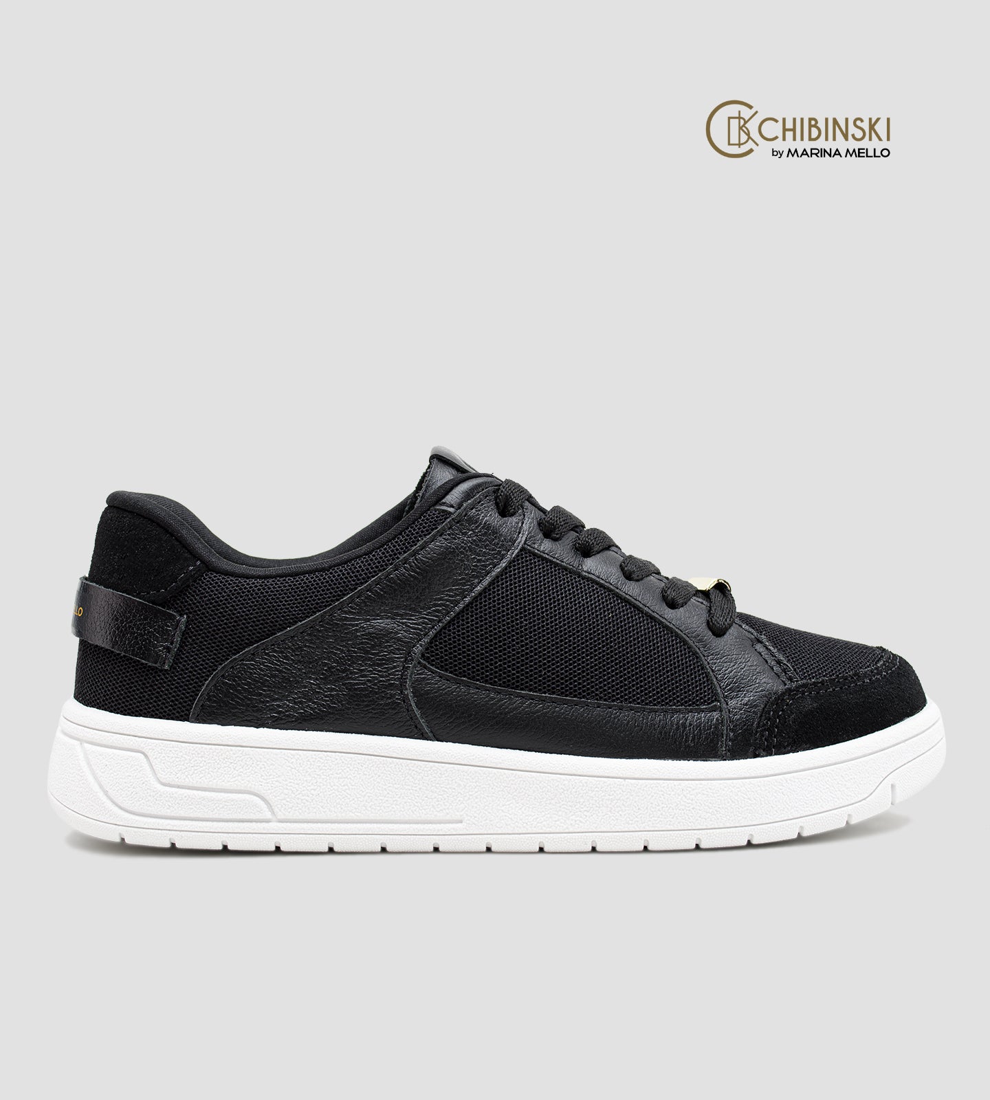 Tênis feminino preto em couro com recortes em tela e suede, solado branco e detalhe Marina Mello no calcanhar, modelo casual com palmilha de gel amortecedor.