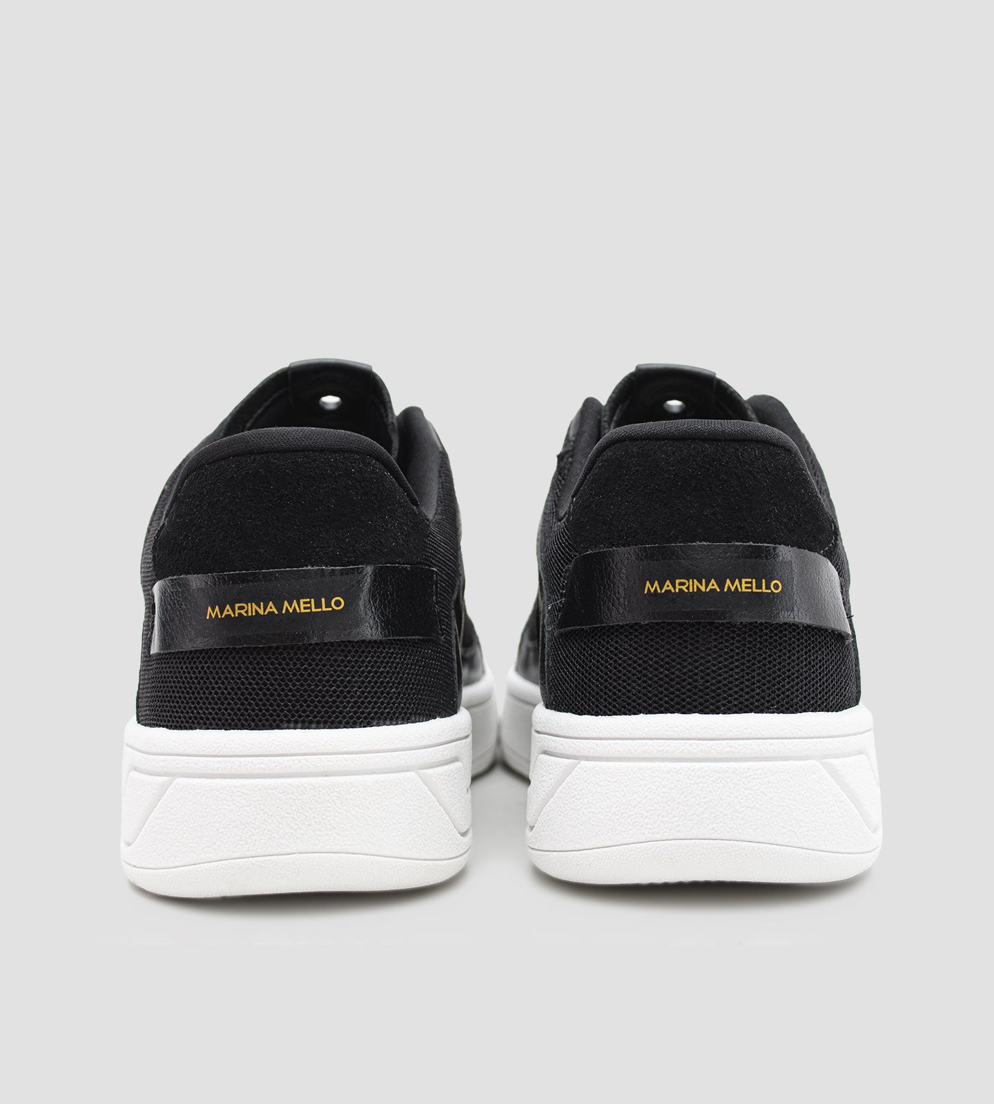 Tênis feminino preto em couro com recortes em tela e suede, solado branco e detalhe Marina Mello no calcanhar, modelo casual com palmilha de gel amortecedor.