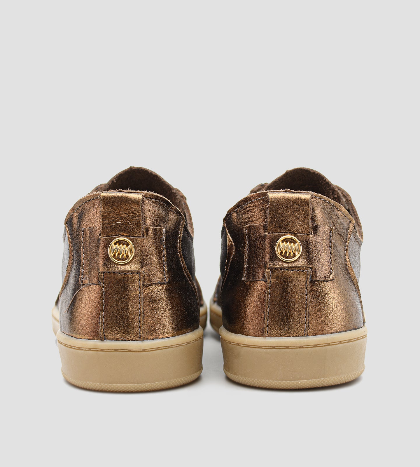 Tênis feminino em couro legítimo bronze metalizado da coleção Chibinski by Marina Mello, com cadarço marrom, solado emborrachado bege e palmilha em gel para maior conforto.