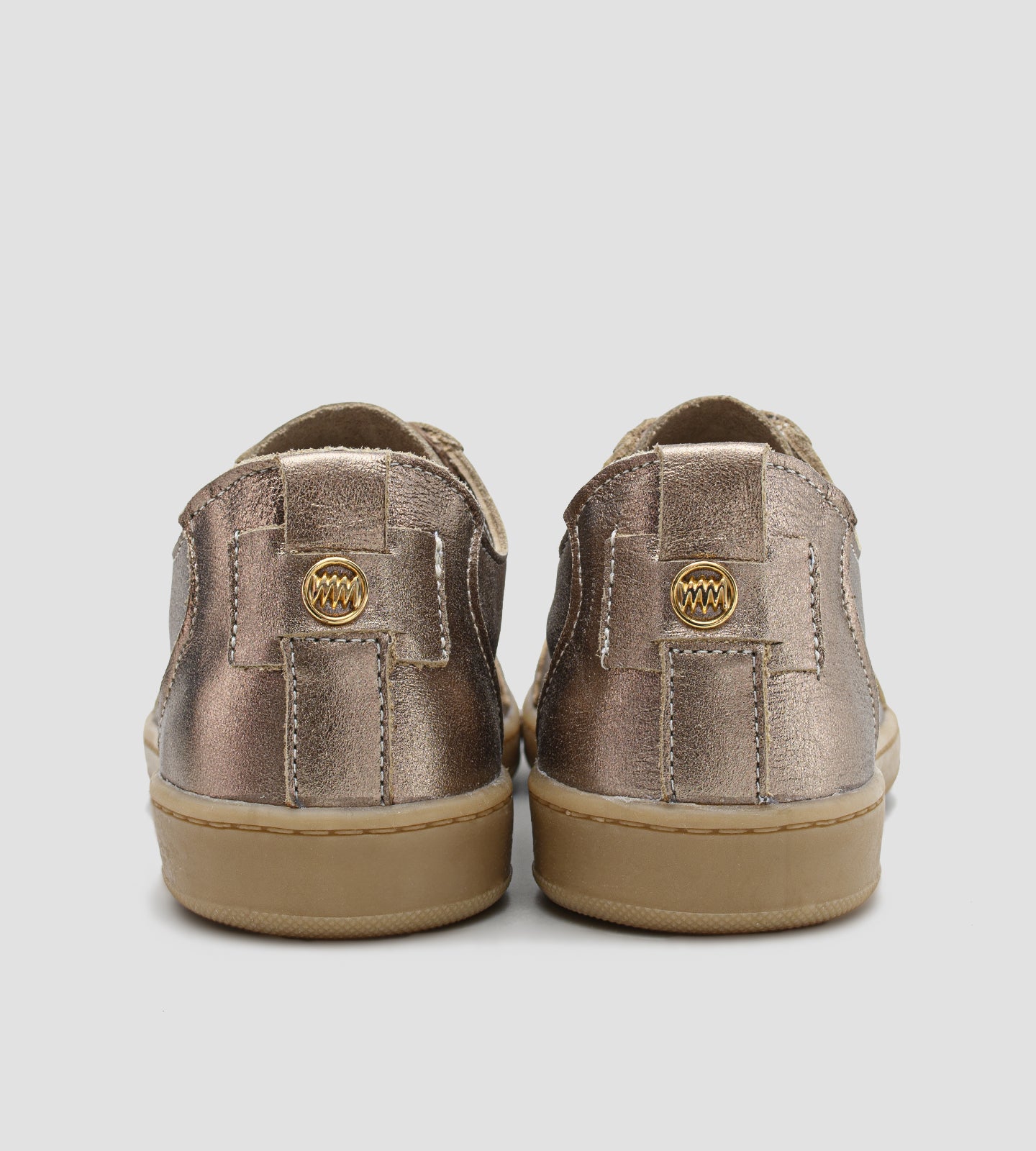 Tênis feminino em couro legítimo dourado metalizado da coleção Chibinski by Marina Mello, com cadarço marrom, solado emborrachado bege e palmilha em gel para maior conforto.