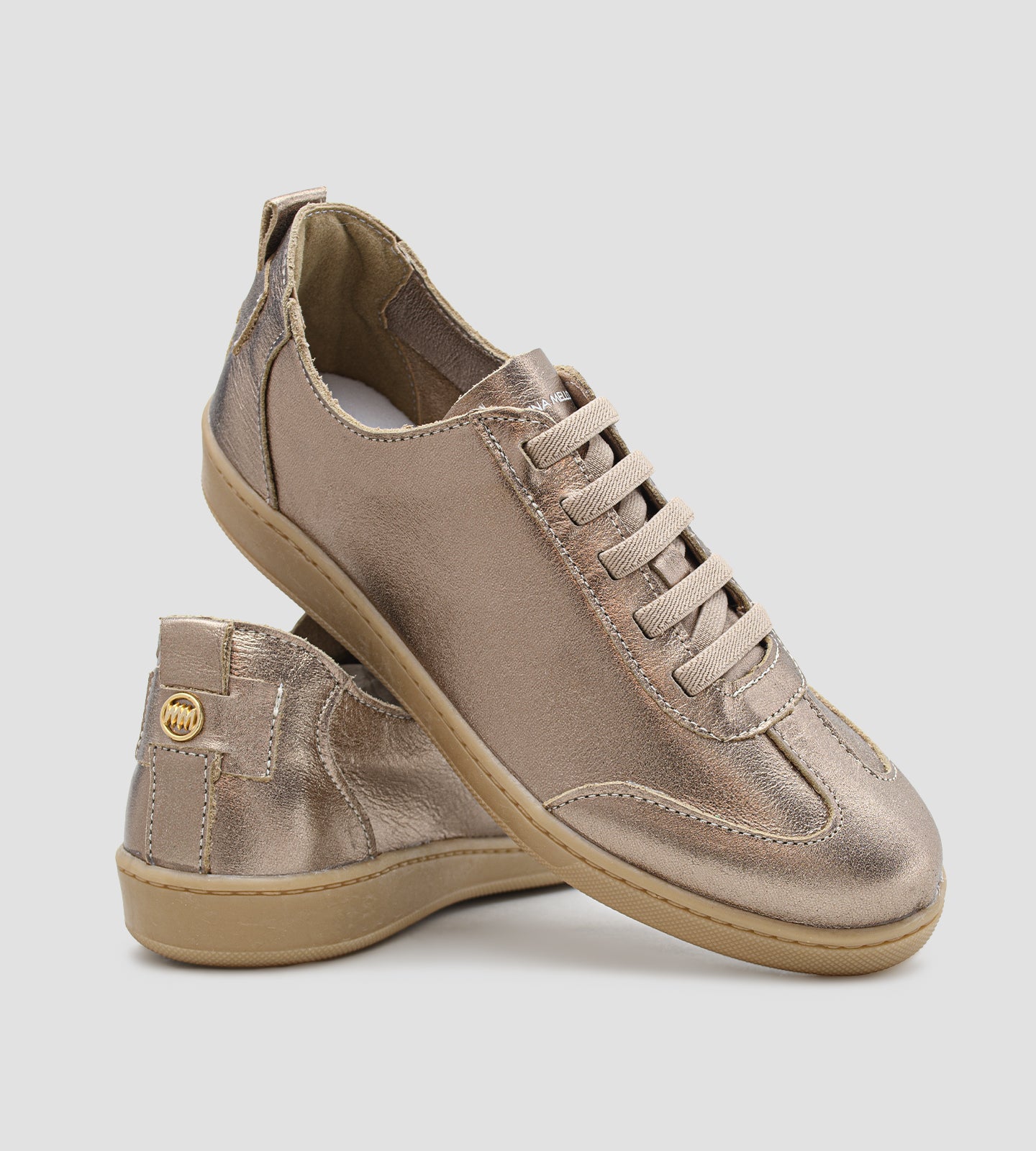 Tênis feminino em couro legítimo dourado metalizado da coleção Chibinski by Marina Mello, com cadarço marrom, solado emborrachado bege e palmilha em gel para maior conforto.