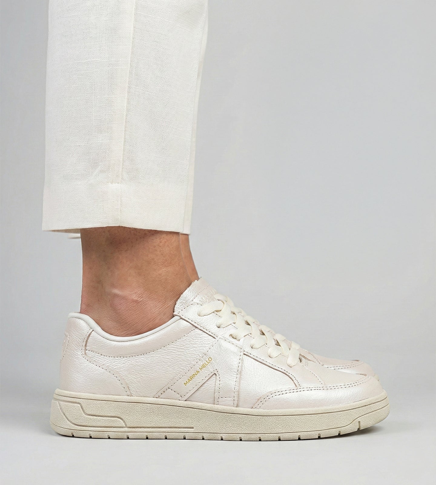 Tênis feminino off white em couro legítimo com design minimalista, solado robusto no mesmo tom e cadarço off white, modelo casual da collab Chibinski by Marina Mello com palmilha de gel amortecedor.