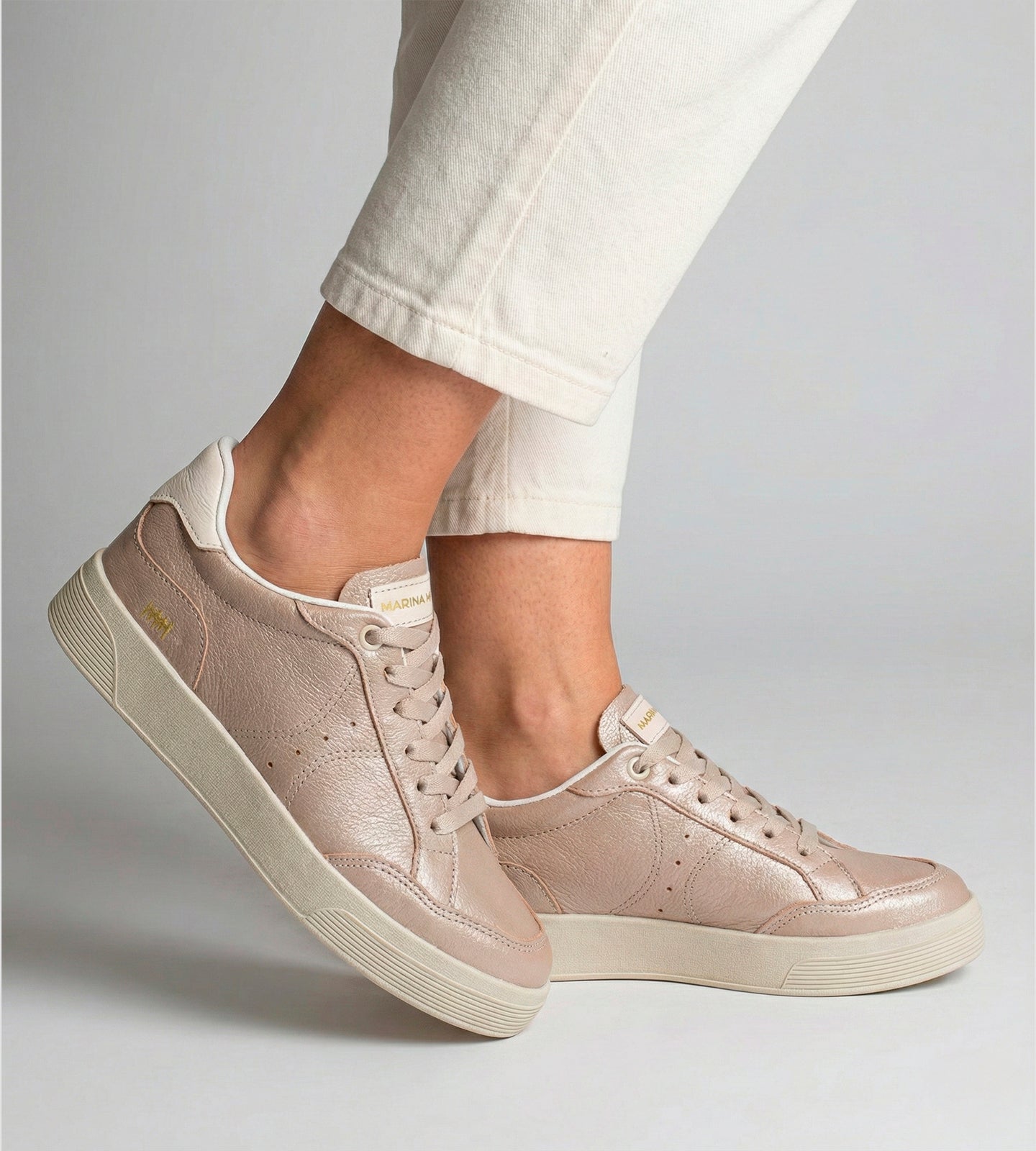 Tênis feminino em couro rosê com cadarço no mesmo tom, solado claro e design casual, modelo da collab com Marina Mello.