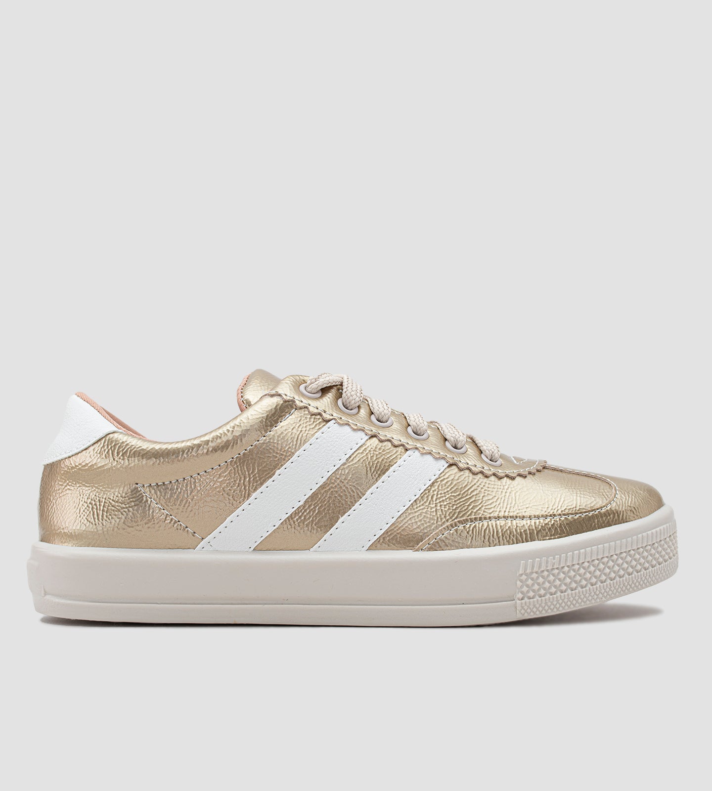Tênis feminino dourado com acabamento metalizado, listras brancas laterais, cadarço bege e solado branco emborrachado, estilo casual e moderno.