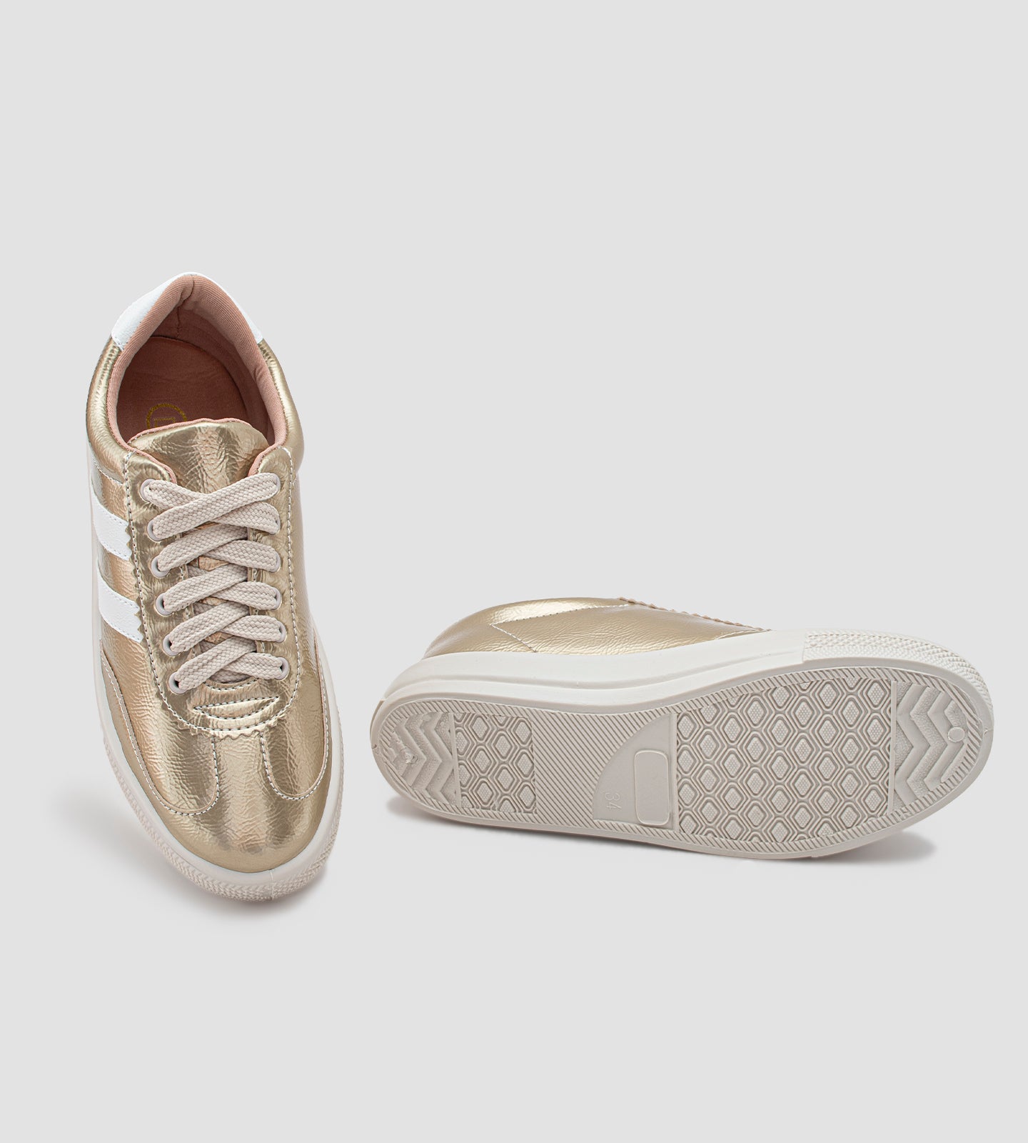 Tênis feminino dourado com acabamento metalizado, listras brancas laterais, cadarço bege e solado branco emborrachado, estilo casual e moderno.