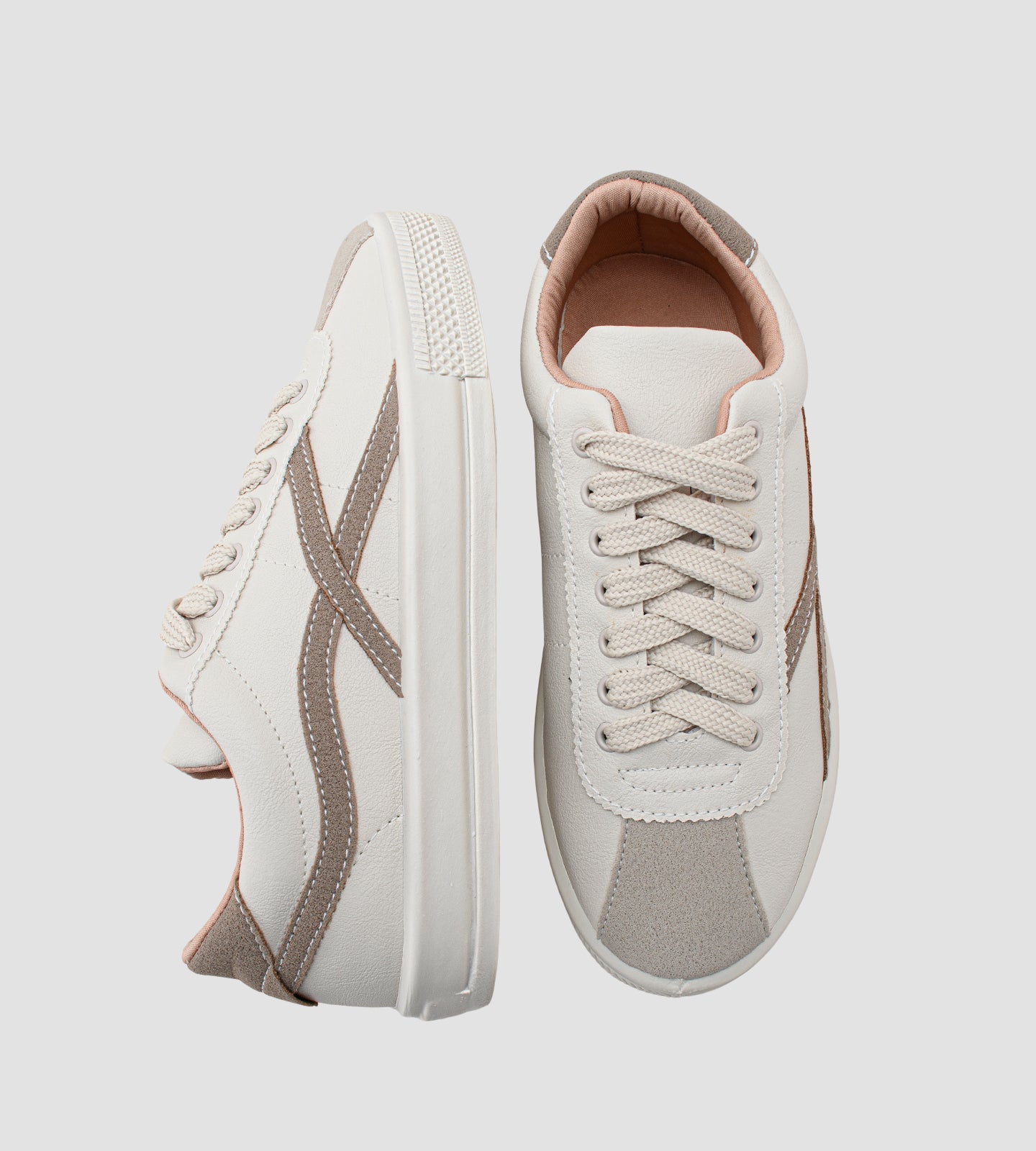 Um tênis casual feminino de cor off-white, com detalhes em bege e um toque sutil de rosa claro, que remete à versatilidade e ao estilo de modelos populares como o Adidas Samba, a silhueta clássica do New Balance 530 e o design consciente dos tênis Veja (anteriormente conhecidos como Vert no Brasil).