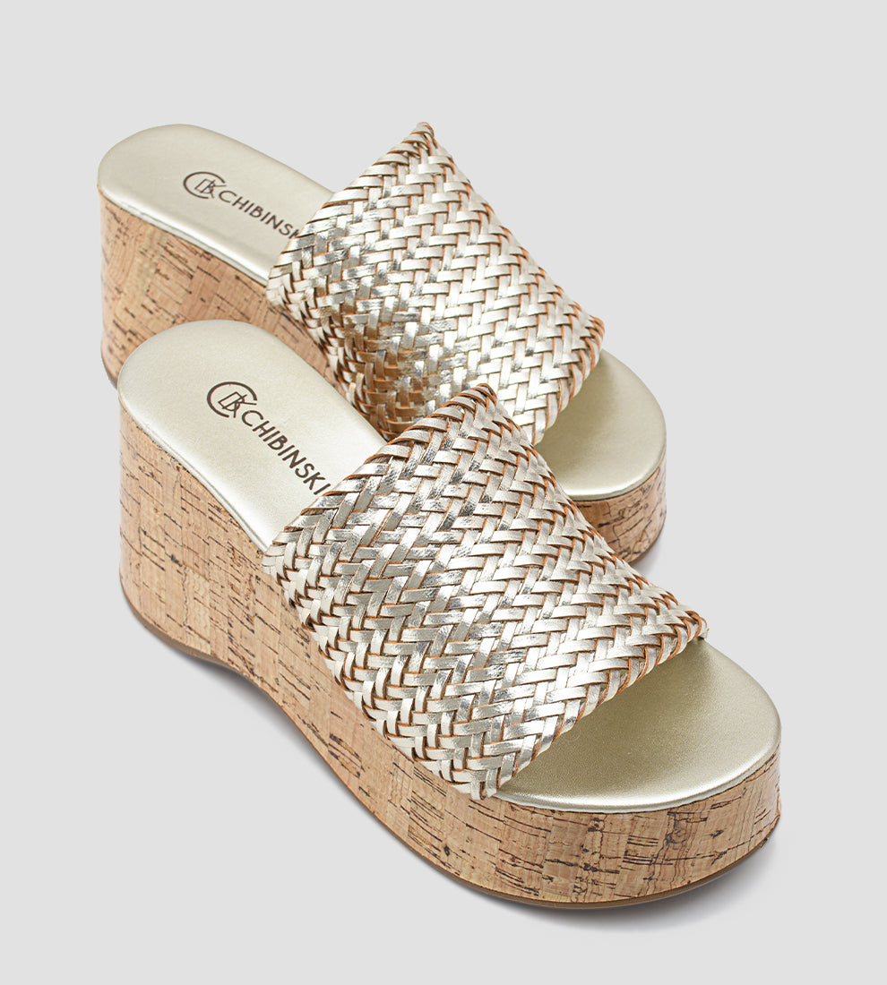 Tamanco feminino dourado com salto plataforma em cortiça e tiras largas trançadas.